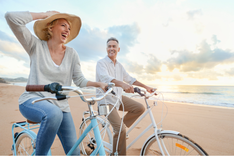 Couple riding their bikes on a beach