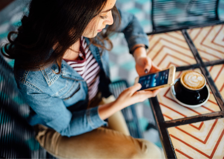 Woman on her phone with a cup of coffee